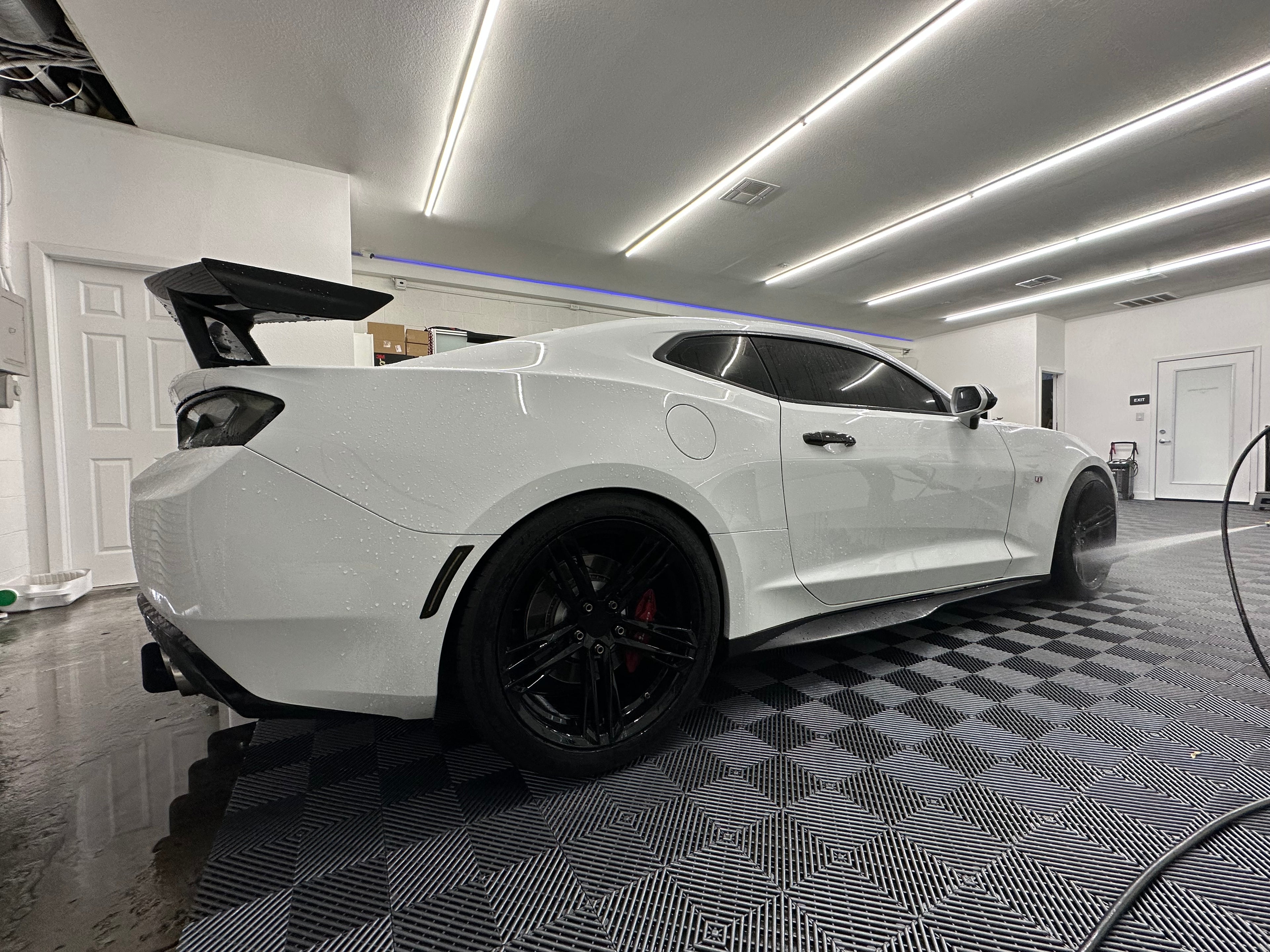 White sports car in a showroom with checkered floor and white walls